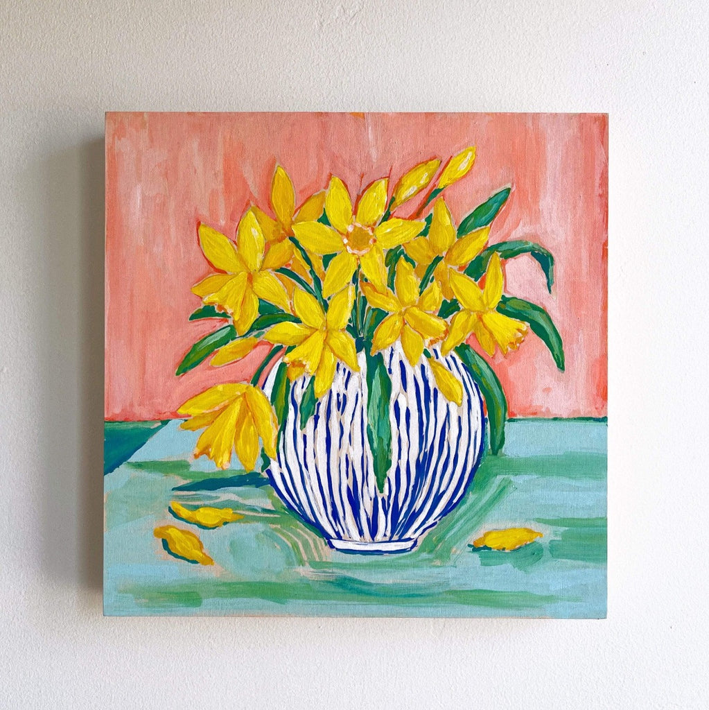 12x12 inch acrylic painting of a bouquet of daffodils bursting from a blue and white striped vase, on a coral and aqua background by Liz Langley.