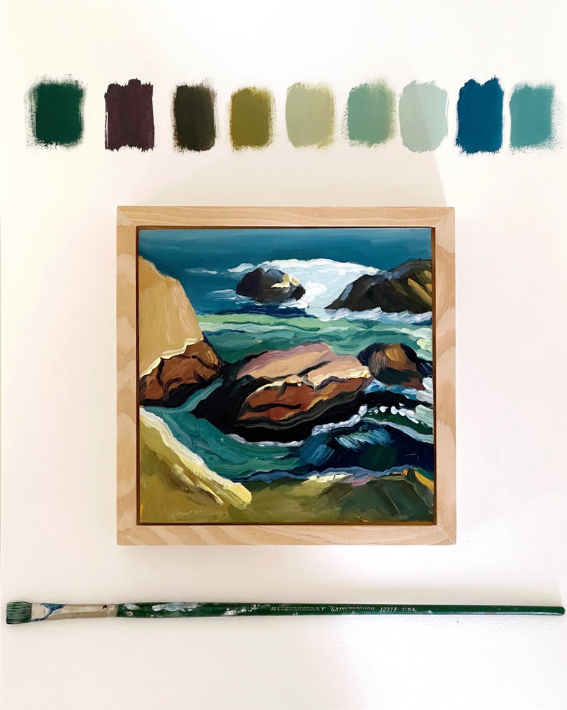 6x6 winter seascape oil on panel in deep blues and greens by Liz Langley Studio. Shown framed with color swatches and paintbrush