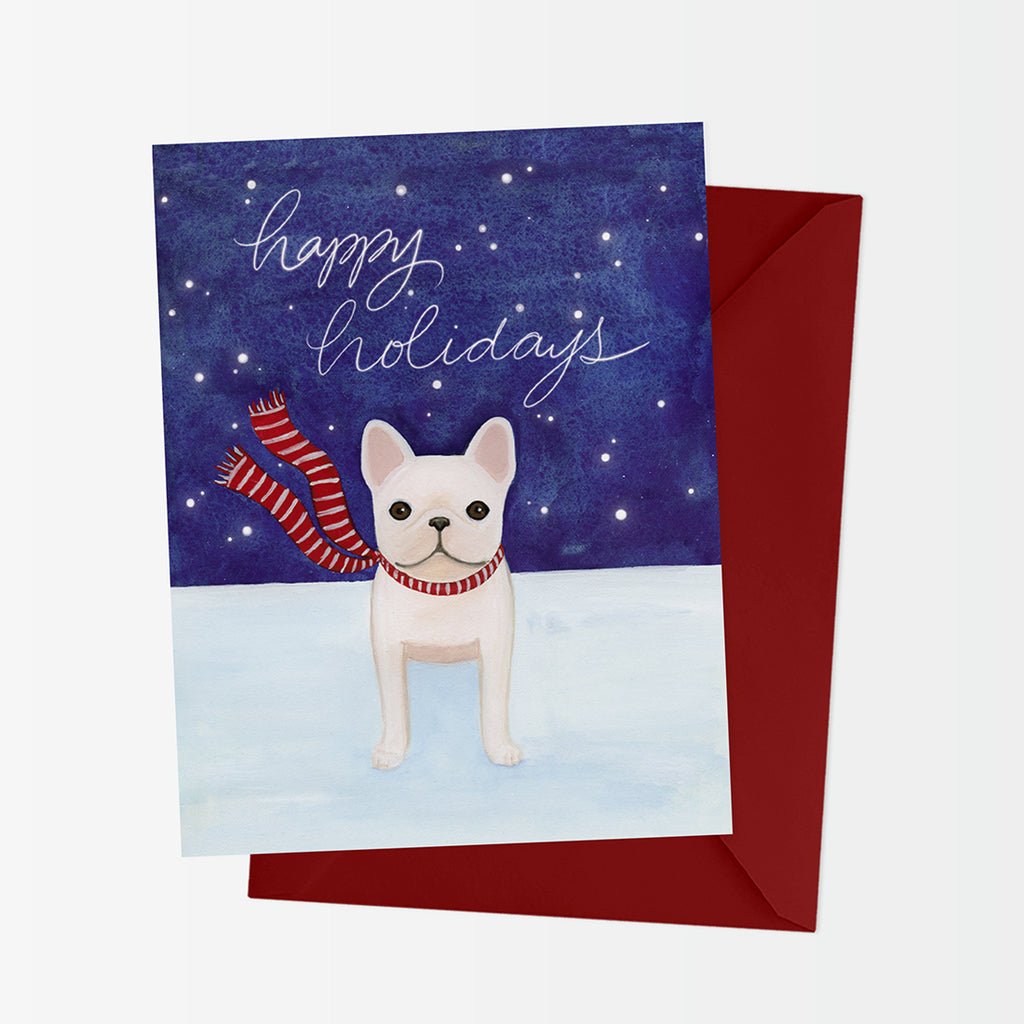 A2 holiday card with a cream french bulldog in red and white striped scarf on a snowy night. Message reads Happy Holidays. Shown with red envelope