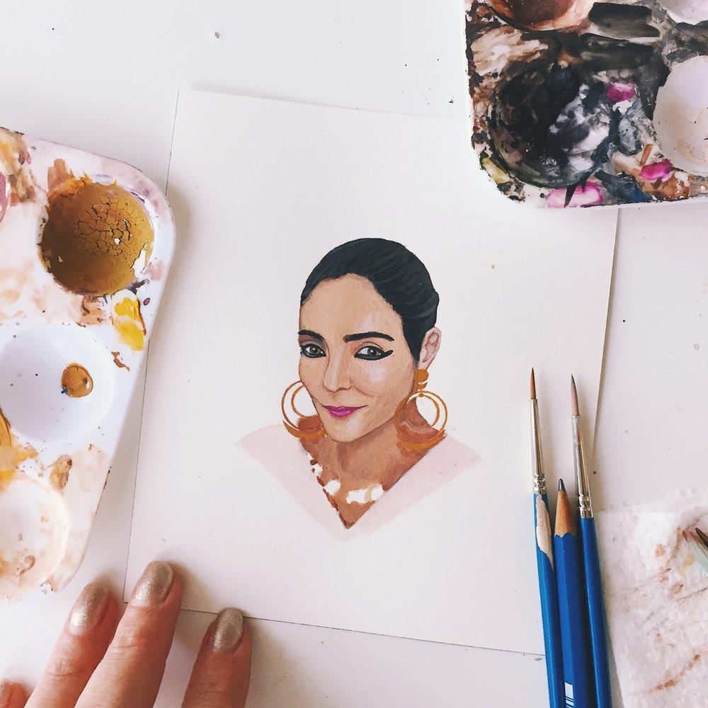 Shirin Neshat portrait in gouache by Liz Langley on studio table with paints and brushes